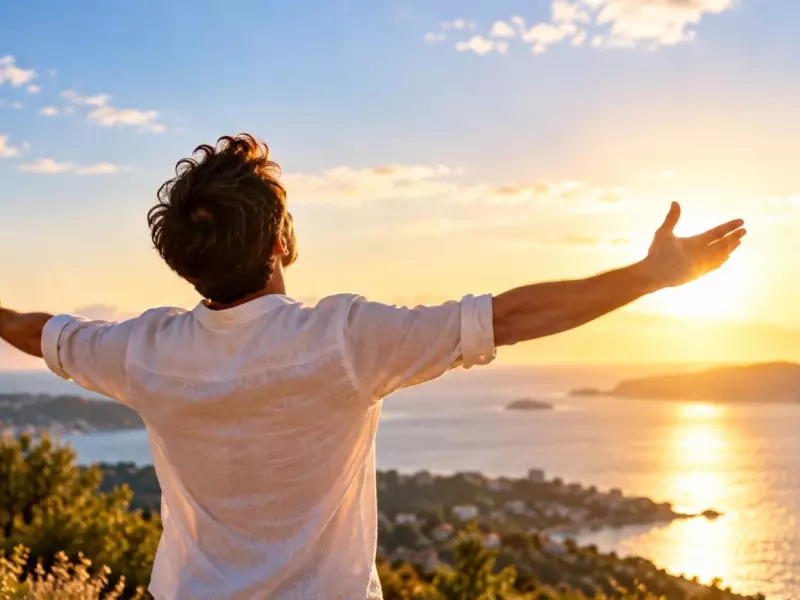 Un homme debout qui ouvre les bras face à la mer